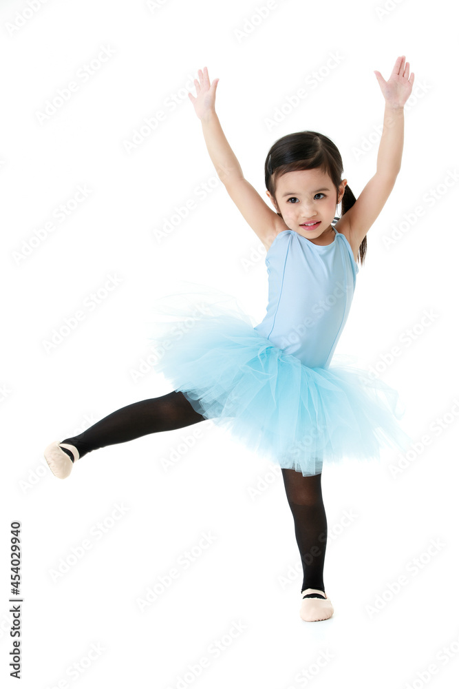 Portrait isolated studio shot of small pretty Asian preschool pigtails ballerina dancer girl in blue tutu ballet dress black legging standing smiling posing hold hands and leg up on white background Portrait isolated studio shot of small pretty Asian preschool pigtails ballerina dancer girl in blue tutu ballet dress black legging standing smiling posing hold hands and leg up on white background