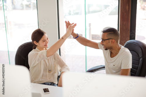 People high fiving in office