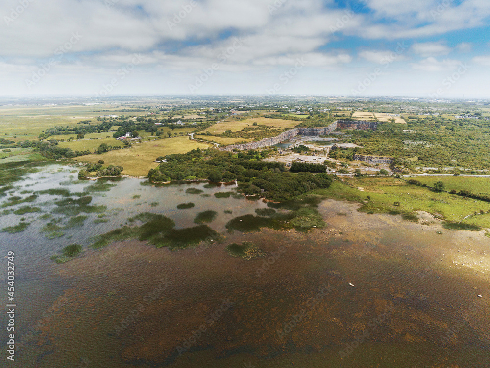 Aerial view on lake Corrib, county Galway, Ireland. Rural landscape. Cloudy sky. Green fields and old abandoned quarry
