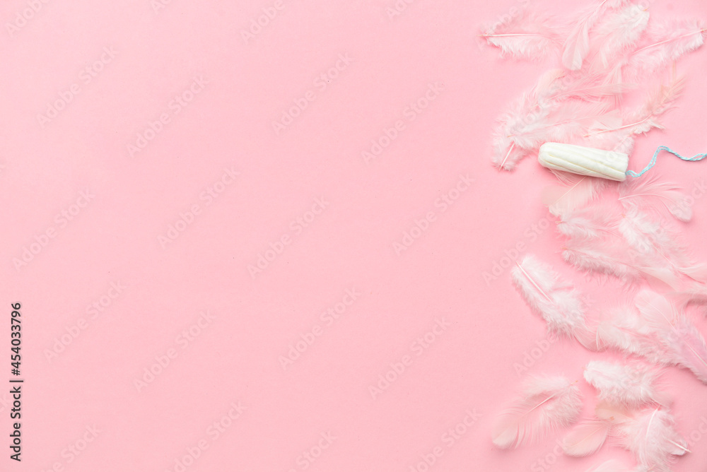 Tampon and feathers on color background Tampon and feathers on color background