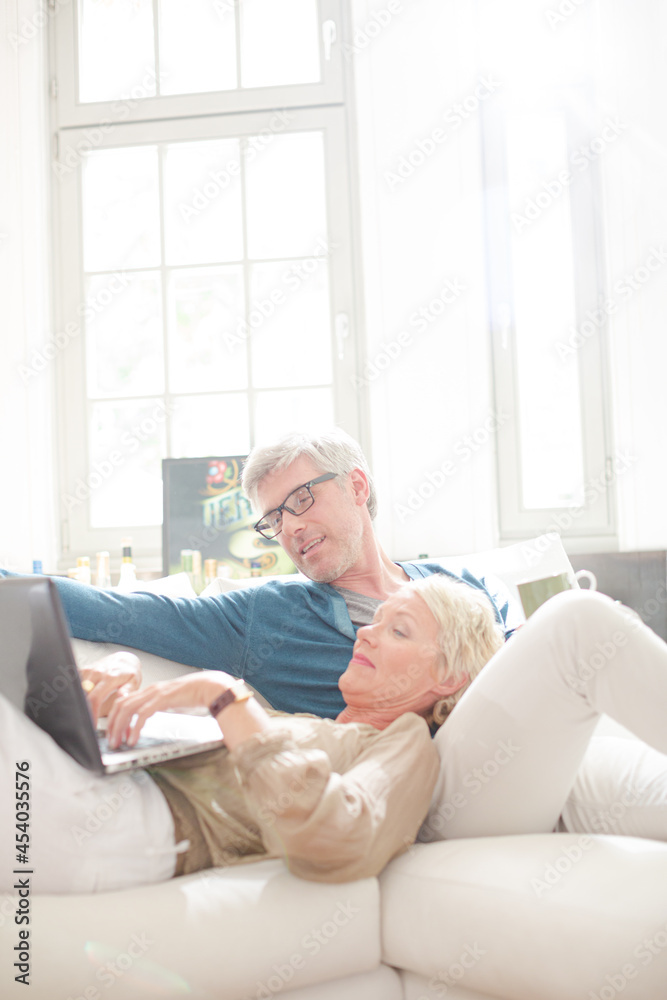Older couple relaxing together on living room sofa Older couple relaxing together on living room sofa