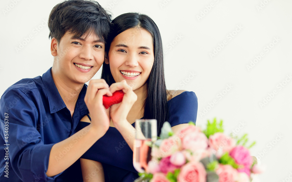 Asian man and woman lovers cuddle hold hands and red heart shape Asian man and woman lovers cuddle hold hands and red heart shape