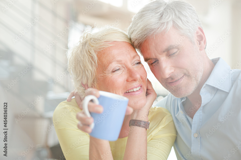 Older couple hugging with coffee cup Older couple hugging with coffee cup