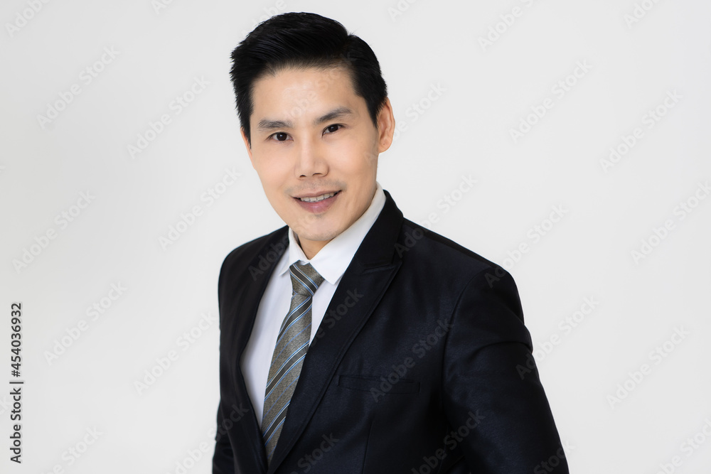 Young and handsome black hair Asian businessman in dark tone suit standing and looking to camera, pose with self-confidence and trust Young and handsome black hair Asian businessman in dark tone suit standing and looking to camera, pose with self-confidence and trust