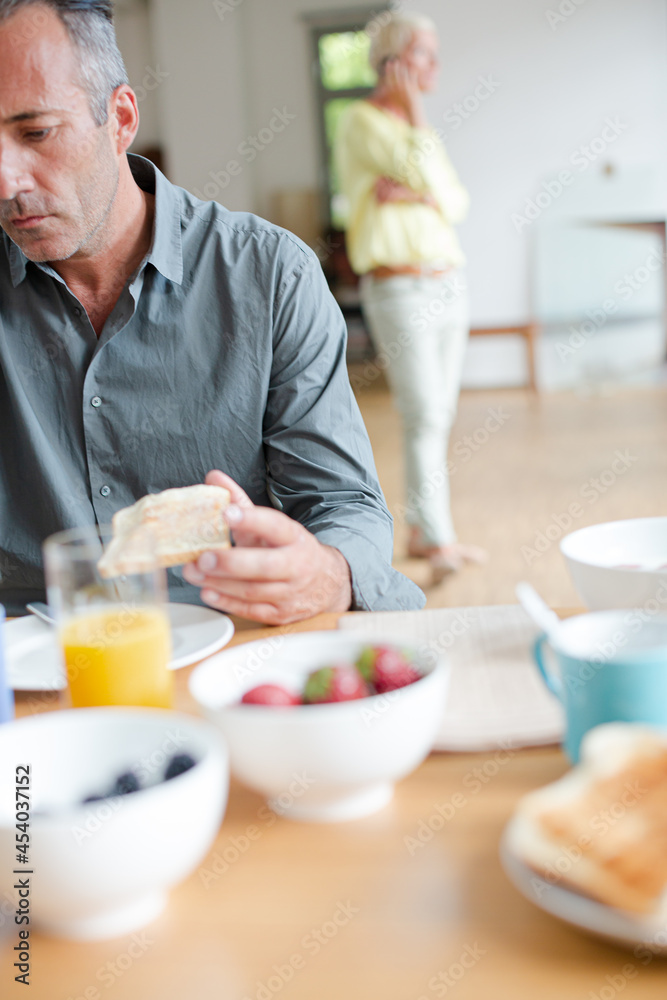 Older man using digital tablet at breakfast table Older man using digital tablet at breakfast table