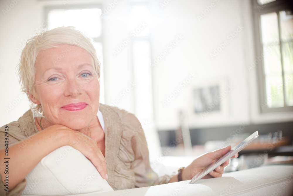 Older woman smiling on sofa Older woman smiling on sofa