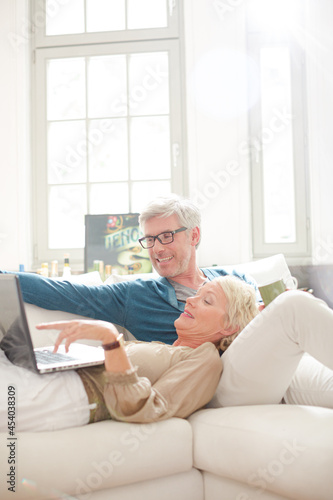 Older couple relaxing together on living room sofa