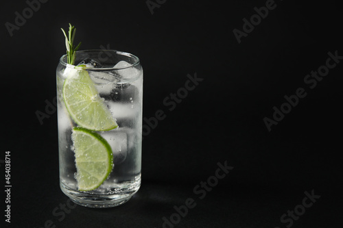 Glass of cold gin and tonic on dark background