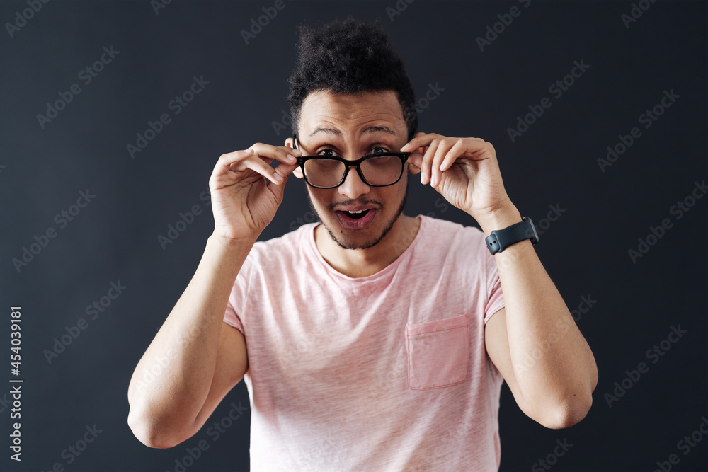 Emotional attractive male with opened mouth expresses great surprisment and frighteness, poses against black background, stares at camera. Unexpected shocking news and human reaction Emotional attractive male with opened mouth expresses great surprisment and frighteness, poses against black background, stares at camera. Unexpected shocking news and human reaction