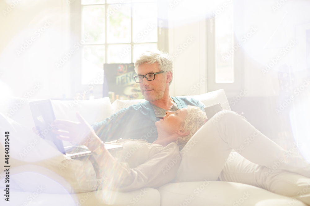 Older couple relaxing together on living room sofa Older couple relaxing together on living room sofa