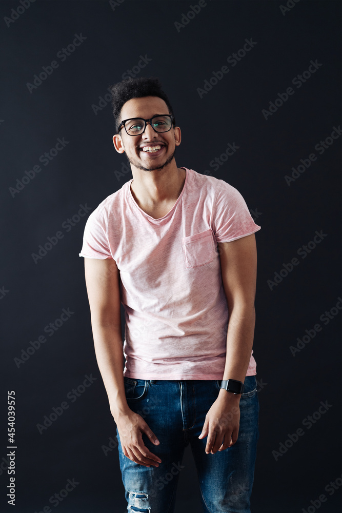 Young handsome man with beard wearing casual t shirt and glasses over black background face smiling looking at the camera with copy space. Positive person. Young handsome man with beard wearing casual t shirt and glasses over black background face smiling looking at the camera with copy space. Positive person.