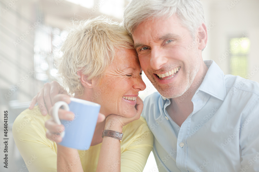 Older couple hugging with coffee cup Older couple hugging with coffee cup