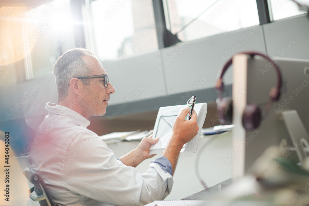 Businessman reading paperwork at home office desk Businessman reading paperwork at home office desk