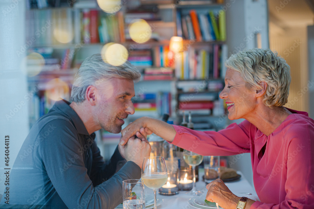 Older man kissing hand of wife at romantic dinner Older man kissing hand of wife at romantic dinner