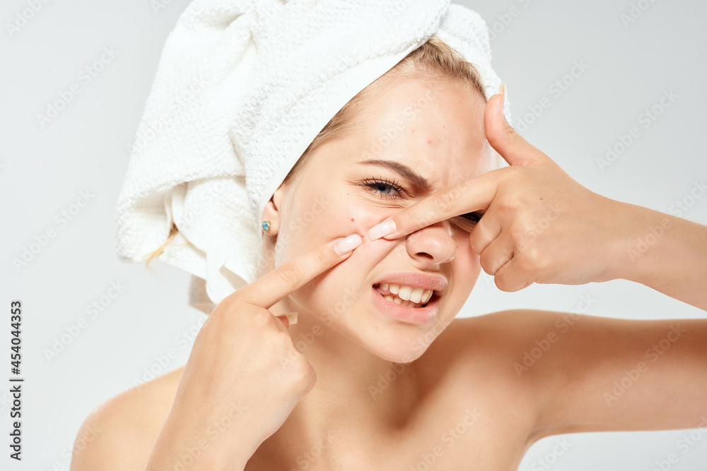 woman with bare shoulders with a towel on her head squeezes out pimples and dermatology hygiene woman with bare shoulders with a towel on her head squeezes out pimples and dermatology hygiene