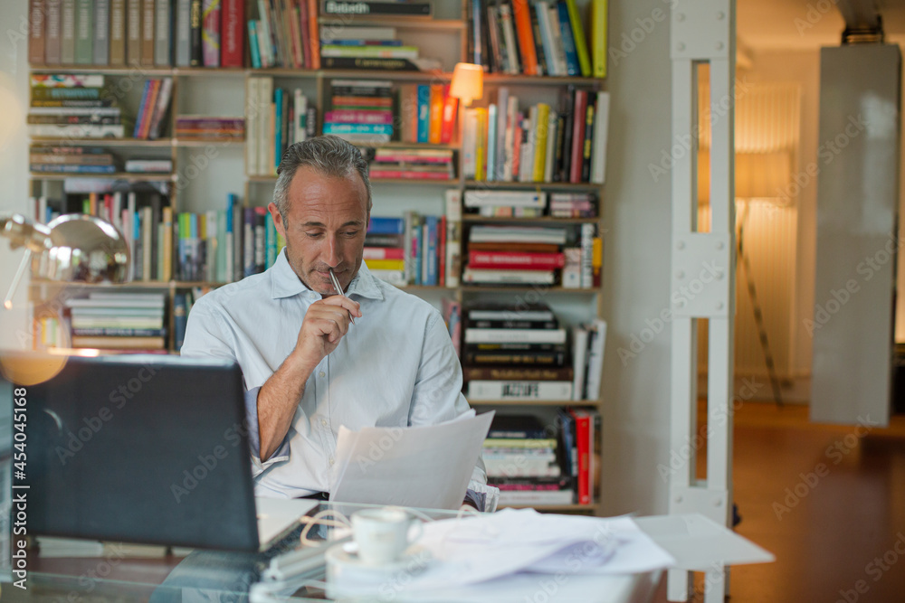 Businessman working on laptop in home office Businessman working on laptop in home office