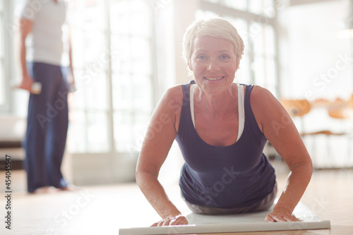 Older woman meditating on exercise mat