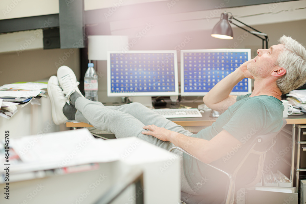 Fototapeta premium Businessman talking on cell phone at office desk