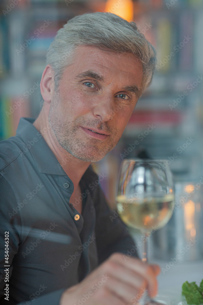Smiling older man toasting with white wine Smiling older man toasting with white wine