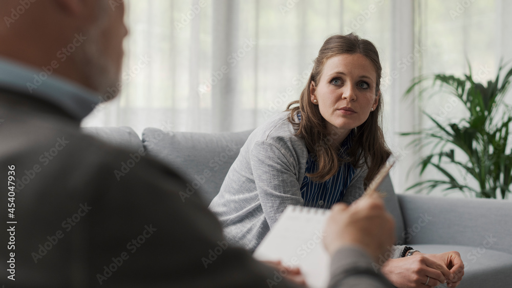 Depressed woman sitting on the therapist couch Depressed woman sitting on the therapist couch