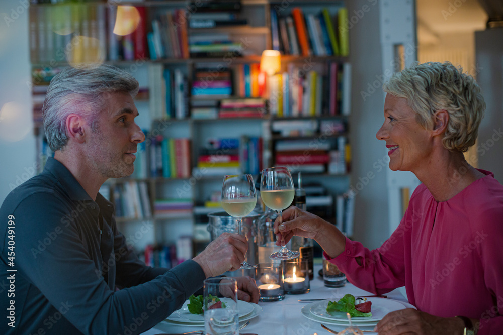 Older couple toasting each other at romantic dinner Older couple toasting each other at romantic dinner