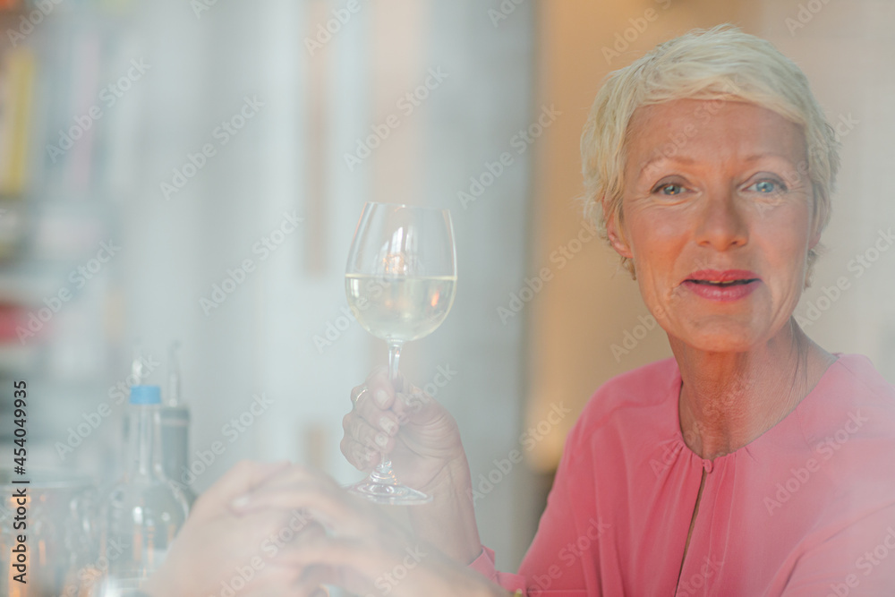 Older woman drinking glass of white wine Older woman drinking glass of white wine