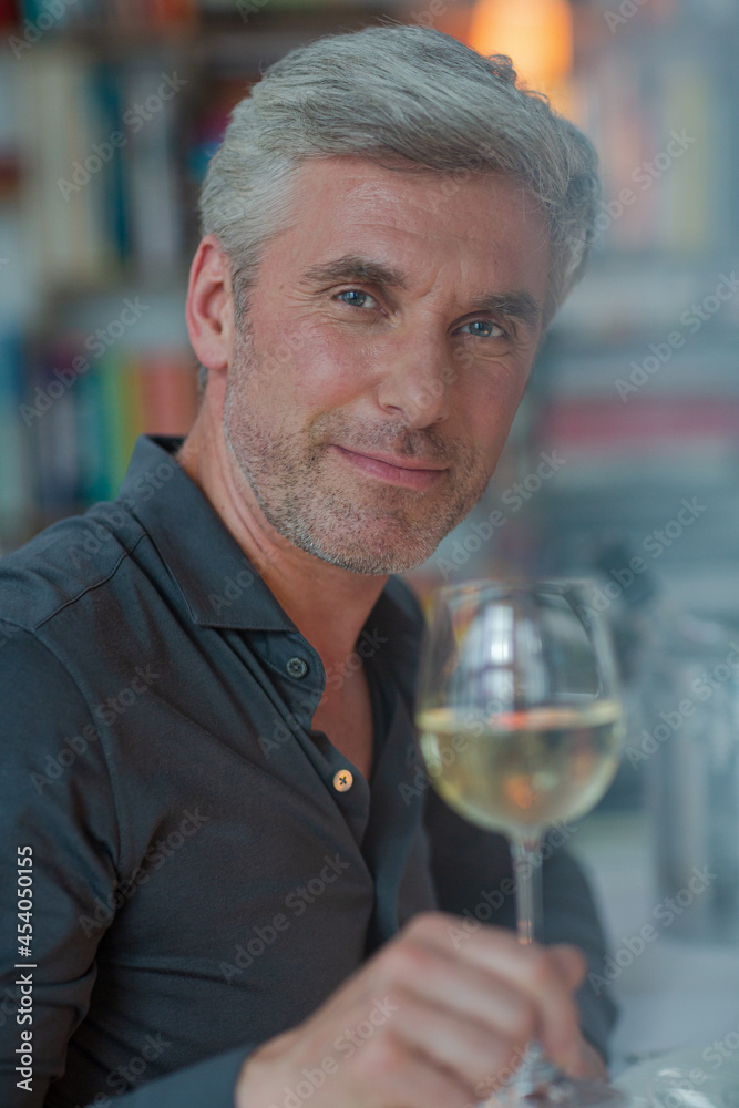 Smiling older man toasting with white wine Smiling older man toasting with white wine