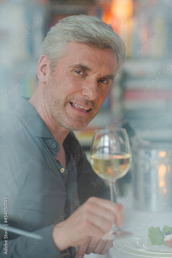 Smiling older man toasting with white wine Smiling older man toasting with white wine