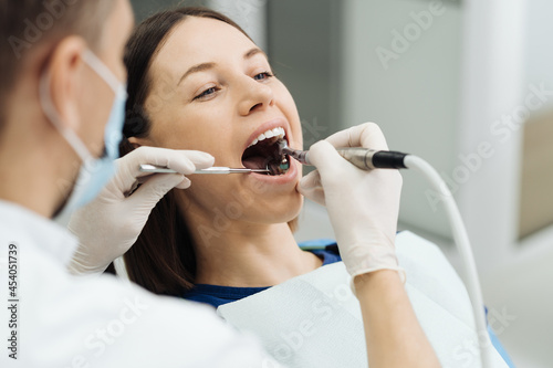 Overview of dental caries prevention. Girl at the dentist chair during a dental scaling procedure. Healthy Smile. photo