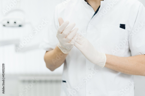 Closeup doctor hands in gloves. Rubber glove manufacturing, human hand is wearing latex gloves. Doctor putting on nitrile protective gloves