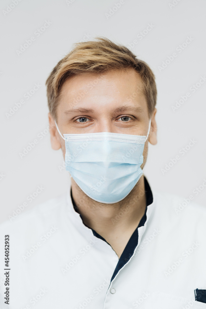 Portrait of a young male medical doctor wear sterile mask isolated on white background Portrait of a young male medical doctor wear sterile mask isolated on white background