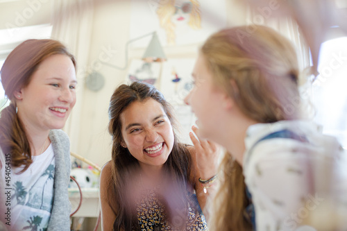 Three teenage girls gossiping in room