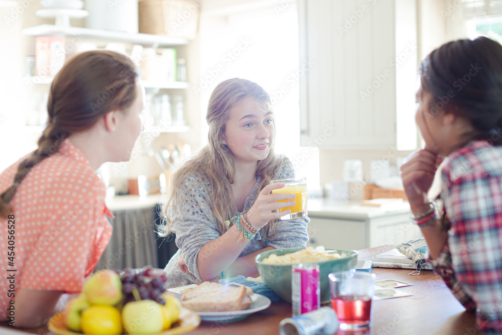 Teenage girls learning at table in kitchen Teenage girls learning at table in kitchen