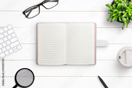 Clean notebook on work desk. Creative flat lay composition on white wooden desk