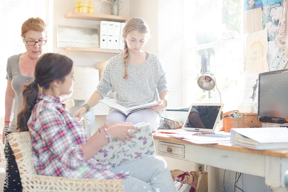 Fototapeta premium Two teenage girls doing homework in room