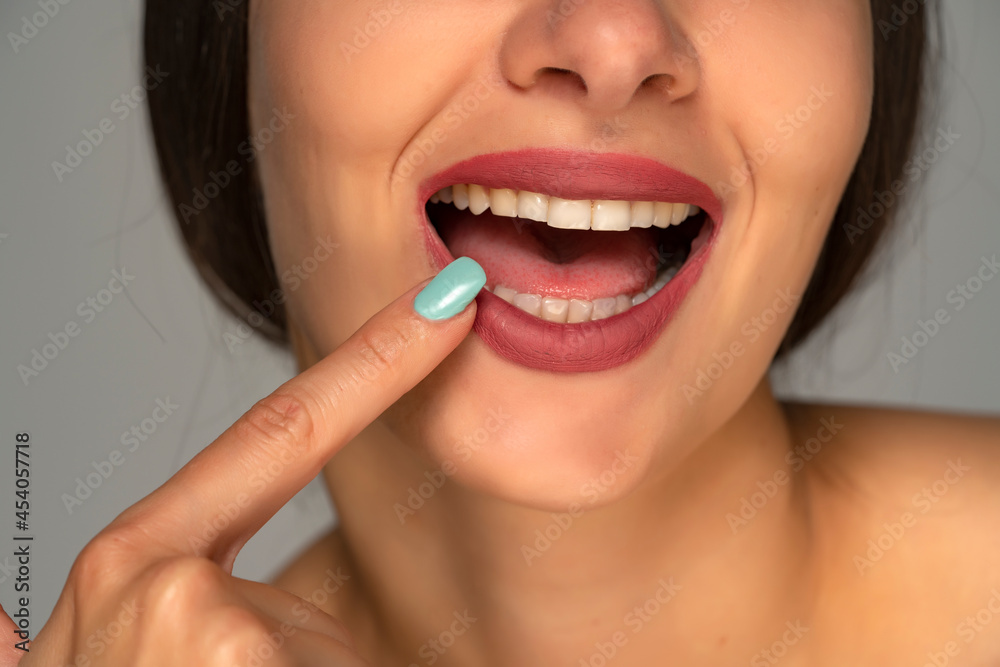 Naklejka premium pointing on her healthy white teeth