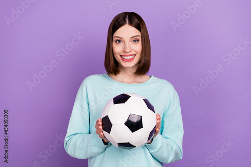 Photo portrait girl keeping soccer ball game fan isolated pastel purple color background © deagreez