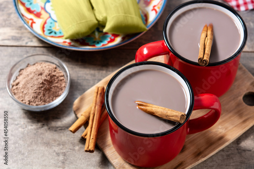 Traditional Mexican chocolate atole drink on wooden table photo