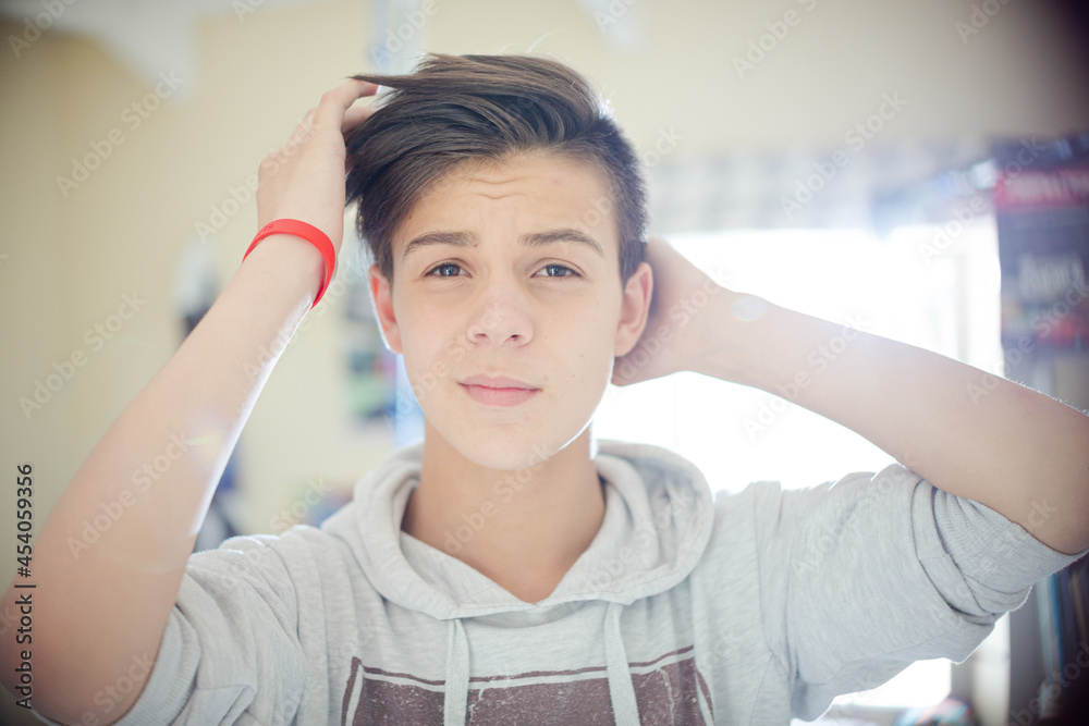 Portrait of teenage boy with hand in hair