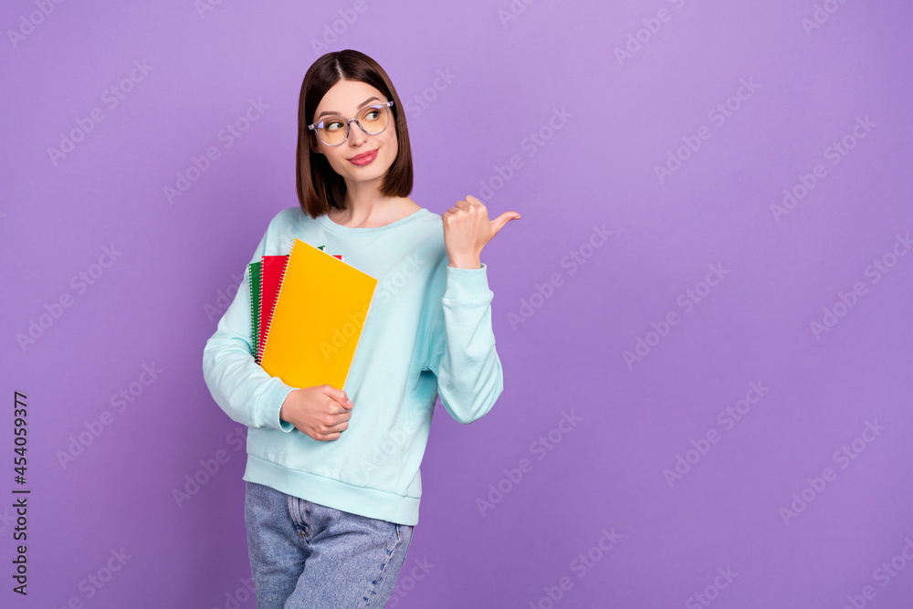 Photo portrait girl keeping book pile showing copyspace thumb isolated pastel purple color background Photo portrait girl keeping book pile showing copyspace thumb isolated pastel purple color background