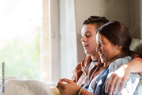 Teenage couple lying in bed and throwing popcorn