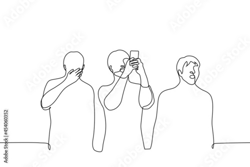 crowd of people stands looking at something with surprise, one of them takes pictures on the phone. concept of a shocking event, a frightening natural phenomenon, a meeting of fans with a celebrity