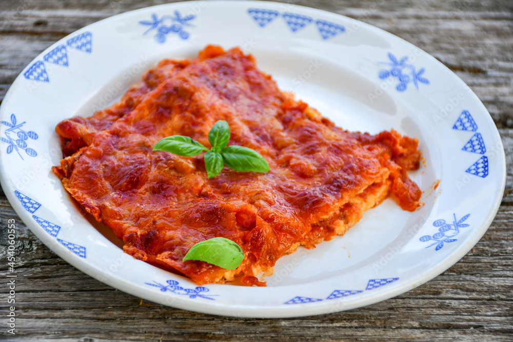 Delicious Home made keto diet Lasagna bolognese with Lupin Flour, minced meat,tomato sauce and spinach on a wooden rustic background.Home made low carb italian meal Delicious Home made keto diet Lasagna bolognese with Lupin Flour, minced meat,tomato sauce and spinach on a wooden rustic background.Home made low carb italian meal