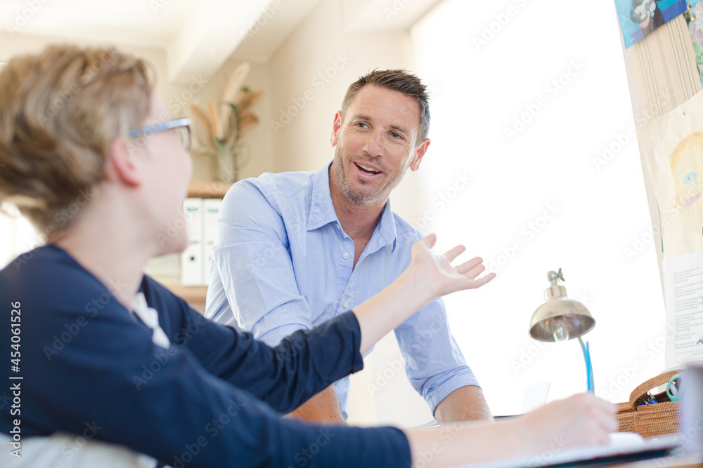 Obraz premium Father helping teenage son doing his homework in room