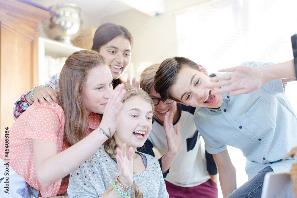 Obraz premium Group of teenagers waving while communicating via internet