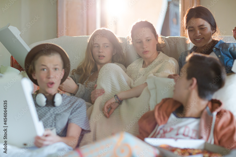 Group of teenagers watching tv on sofa together Group of teenagers watching tv on sofa together