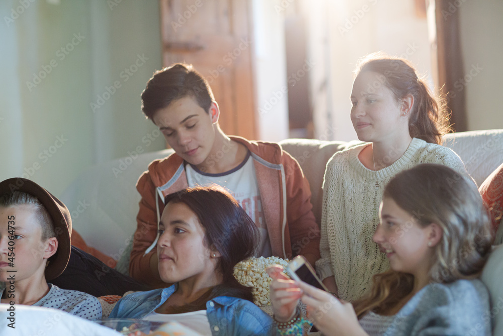 Group of teenagers having fun while watching tv on sofa Group of teenagers having fun while watching tv on sofa