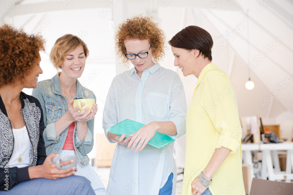 Obraz premium Women with coffe cup talking in office