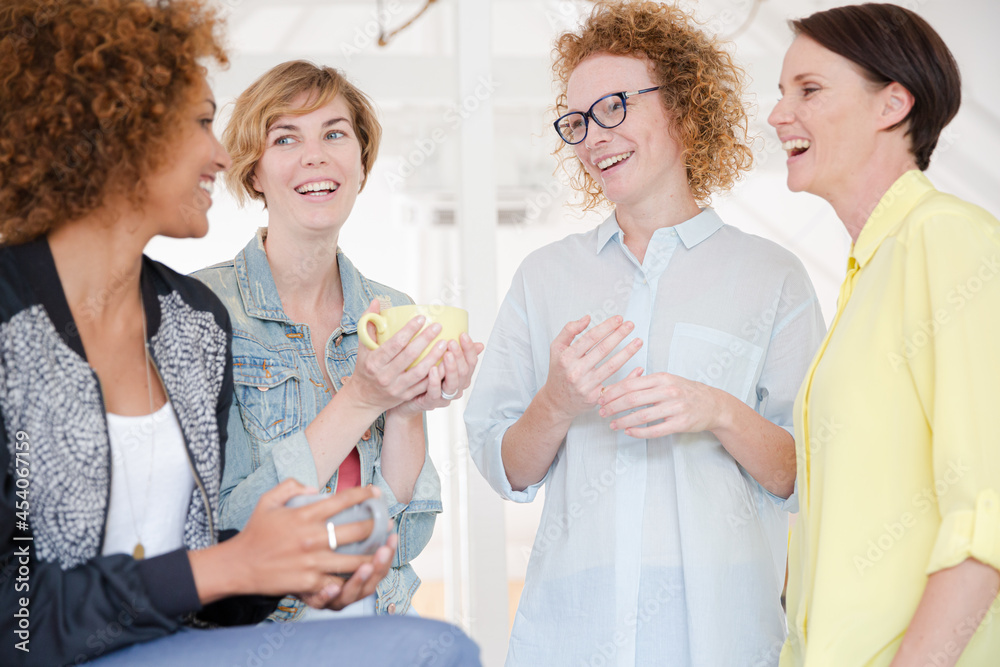 Women with coffe cup smiling in office Women with coffe cup smiling in office