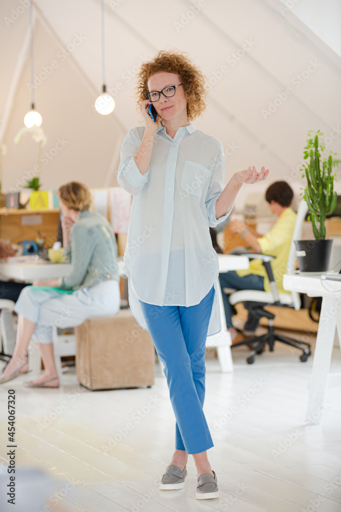 Obraz premium Portrait of woman talking on phone at office